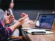 person gesturing during meeting with laptop