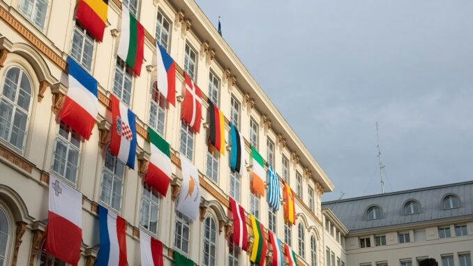 a building with a bunch of flags hanging from it's sides