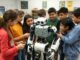 Children surround and interact with a large robot